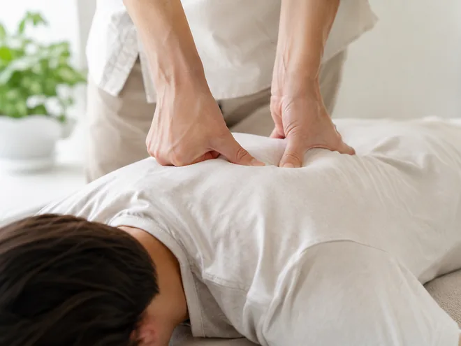 Hands applying pressure through clothing during a Meridian Massage session